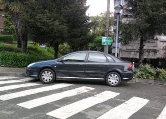 Coche aparcado en entrada garajes y paso de cebra