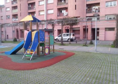 Coches en parque infantil y plaza peatonal