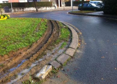 El camión de la basura destroza la rotonda de hierba y el bordillo