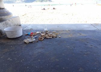 colillas y cristales en la playa de La Concha