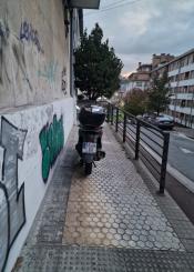 Moto en la acera de uns zona de acceso a garaje