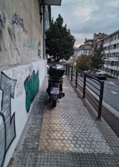 Moto en la acera de uns zona de acceso a garaje